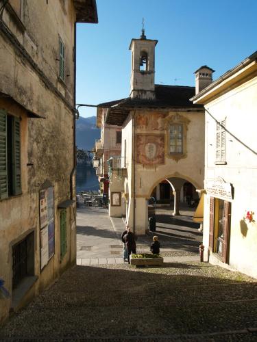 two people sitting on a street in a city at -Ortaflats- Appartamento l'Isola in Orta San Giulio