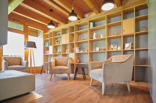 a living room with chairs and a table and shelves at Reka-Feriendorf Wildhaus in Wildhaus