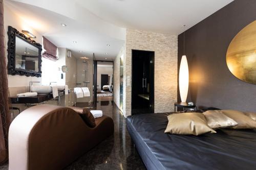 a bedroom with a bed and a bathroom at Maiers Kuschelhotel Loipersdorf - ADULTS ONLY in Loipersdorf bei Fürstenfeld