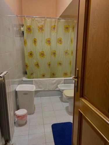 a bathroom with a toilet and a shower curtain at il rifugio della cava in Orvieto