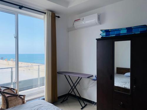 a bedroom with a bed and a desk and a window at Blue Star Apartments three bedroom apartment in Dehiwala