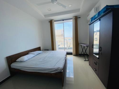 a bedroom with a bed and a large window at Blue Star Apartments three bedroom apartment in Dehiwala