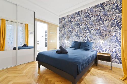 - une chambre avec un lit bleu et un mur bleu et blanc dans l'établissement Charmant Appartement Arc de Triomphe Free Netflix, à Paris