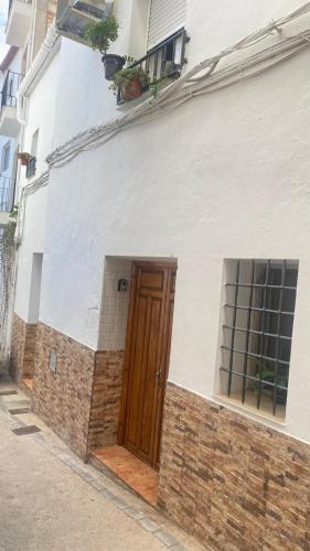 a white building with a brown door on it at Apartamento Nanda in Quesada