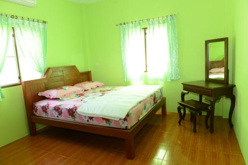 a bedroom with a bed and a mirror and a table at New Sunrise Village in Mae Nam