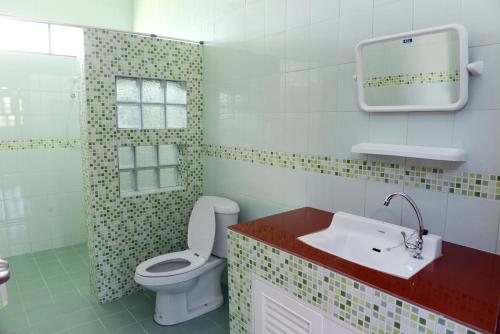 a bathroom with a toilet and a sink at New Sunrise Village in Mae Nam