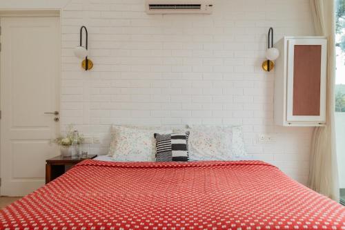 a bedroom with a bed with a red comforter at El Rocio Estate 2bhk in Assagao with Common pool, Free Parking,8 min away from Vagator in Assagao
