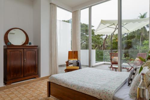 a bedroom with a bed and a large window at El Rocio Estate 2bhk in Assagao with Common pool, Free Parking,8 min away from Vagator in Assagao