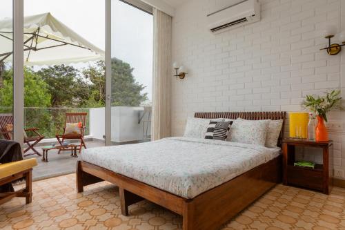 a bedroom with a bed and a patio at El Rocio Estate 2bhk in Assagao with Common pool, Free Parking,8 min away from Vagator in Assagao