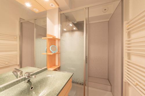 a bathroom with a glass shower and a sink at Le Village des Thermes in Vignec