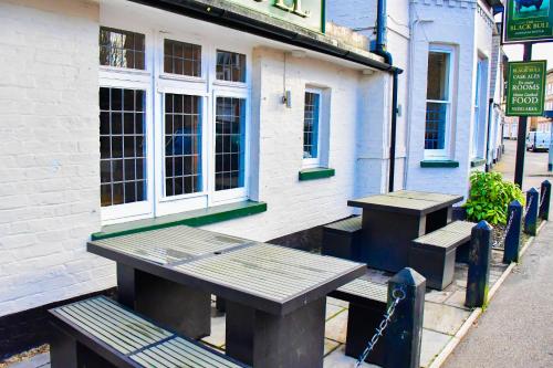 two picnic tables and benches outside of a building at Black Bull Godmanchester in Huntingdon