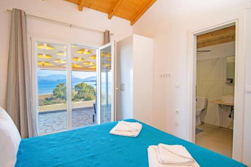 a bedroom with a blue bed and a view of the ocean at Villa Katostrato Beach by Villa Plus in Apraos