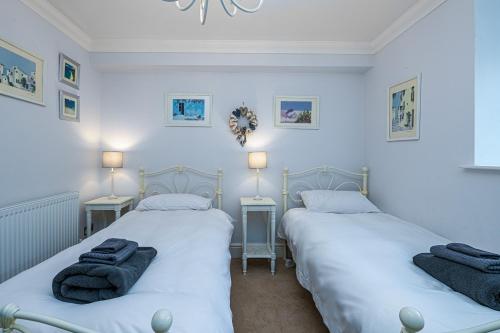 two beds in a room with two lamps and towels at Snowdonia View in Llanfairpwllgwyngyll