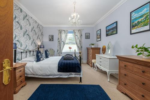 a bedroom with a bed and a dresser and a window at Snowdonia View in Llanfairpwllgwyngyll