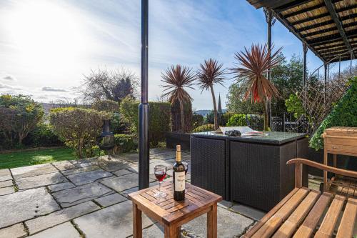 a bottle of wine on a table on a patio at Snowdonia View in Llanfairpwllgwyngyll