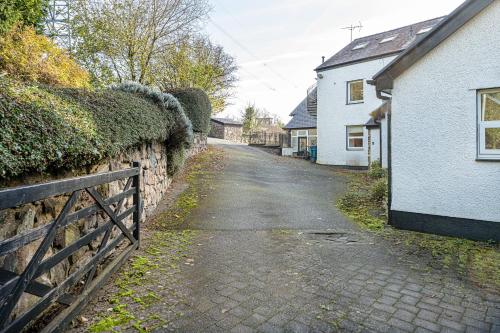 an empty street next to a stone wall at Snowdonia View in Llanfairpwllgwyngyll