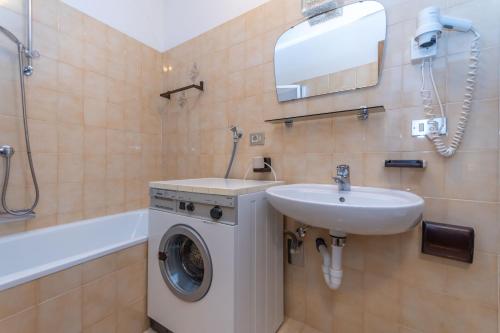 Un baño con lavadora y lavabo. en Appartamento Lucia 201, en Vigo di Fassa