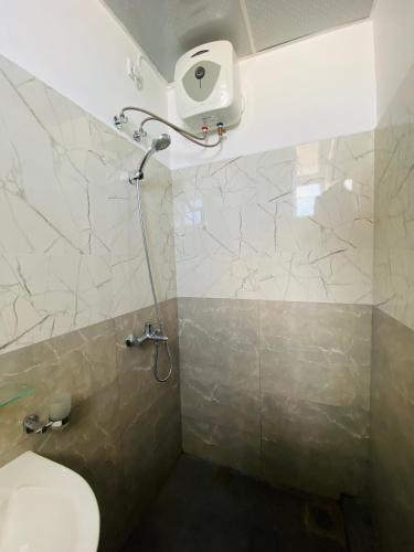 a bathroom with a toilet and a shower at Blue Star Apartments three bedroom apartment in Dehiwala