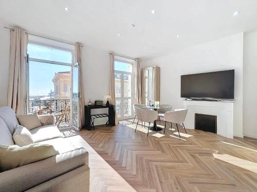 un salon avec un canapé et une table avec une télévision dans l'établissement DELUXE SEAVIEW BALCONY - 2 min PALAIS & BEACH, à Cannes
