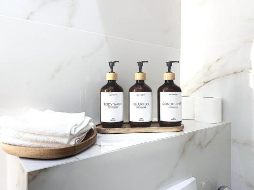 four bottles of wine sitting on a shelf in a bathroom at DELUXE SEAVIEW BALCONY - 2 min PALAIS & BEACH in Cannes