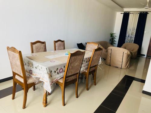 a dining room table and chairs in a living room at Blue Star Apartments three bedroom apartment in Dehiwala