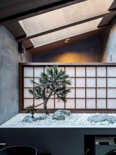 a room with a tree in the middle of a room at Ichika Machiya House in Takayama