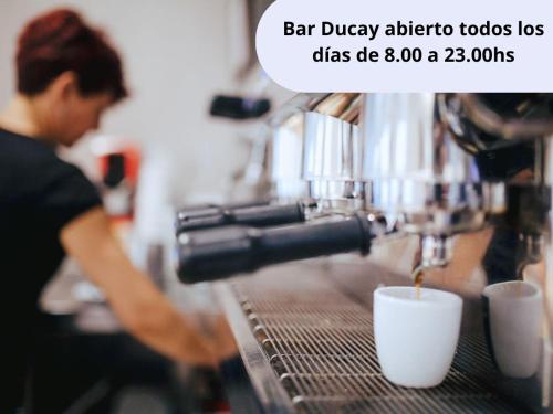 a person making a cup of coffee in a coffee shop at Hotel Rooms Ducay in Olite