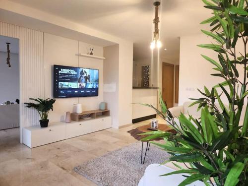 a living room with a flat screen tv on a wall at Luxueux appartement de plage Surf & Golf Néroli 13 in Tamraght Ouzdar