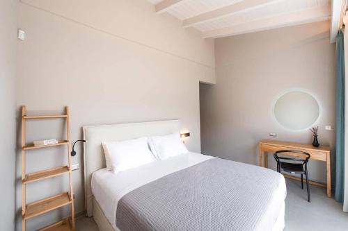 a bedroom with a bed and a desk and a mirror at Villa Angelou Nidri by Villa Plus in Nydri
