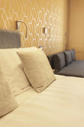a bed with a pillow on top of it at Rooms at The Vault in Buxton