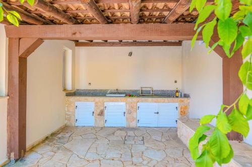 un garage vide avec des portes bleues et un sol en pierre dans l'établissement Villa Oceana by Villa Plus, à Neo Chorio