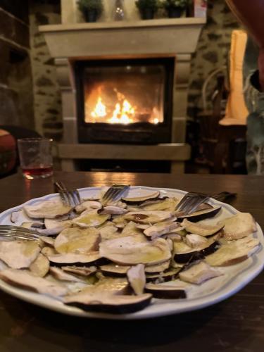 une assiette de nourriture sur une table devant une cheminée dans l'établissement Le Battut, à Beaulieu-sur-Dordogne