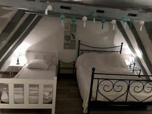 une chambre avec deux lits dans un grenier dans l'établissement Le Battut, à Beaulieu-sur-Dordogne