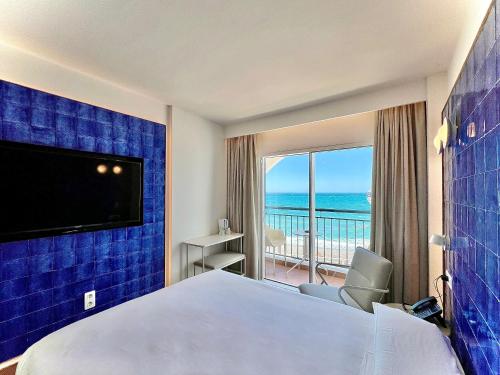 a hotel room with a bed and a view of the ocean at Perla Marina in Nerja