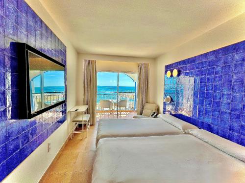a hotel room with a bed and a view of the ocean at Perla Marina in Nerja
