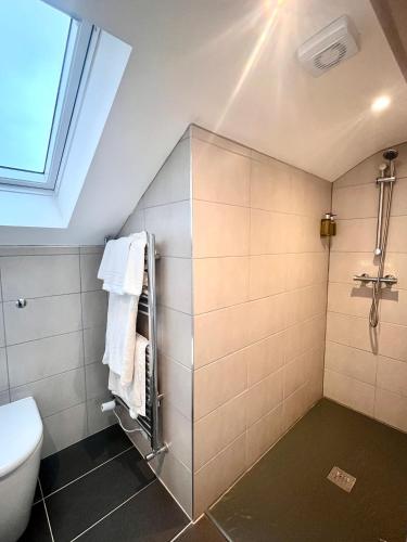 a bathroom with a toilet and a window at Mode Cottage in Lytham St Annes