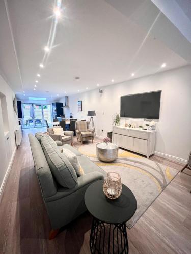 a living room with a couch and a flat screen tv at Mode Cottage in Lytham St Annes