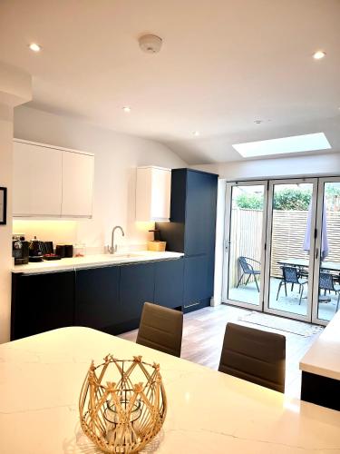 a kitchen with a table and a kitchen with a view at Mode Cottage in Lytham St Annes