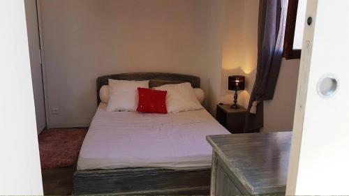 - une petite chambre avec un lit et un oreiller rouge dans l'établissement Superbe pavillon de vacances climatisé avec piscine collective -6CYC62, à Saint Cyprien Plage