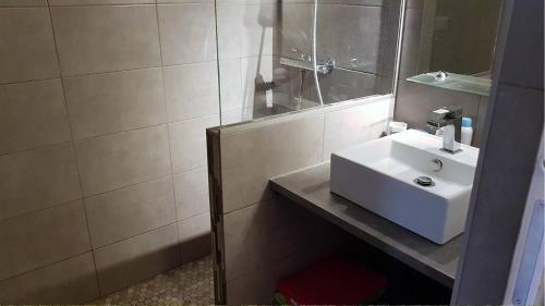 une salle de bain avec un lavabo blanc et un miroir dans l'établissement Superbe pavillon de vacances climatisé avec piscine collective -6CYC62, à Saint Cyprien Plage