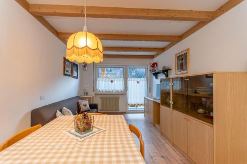 cocina y comedor con mesa y lámpara de araña en Appartamento Lucia 203, en Vigo di Fassa