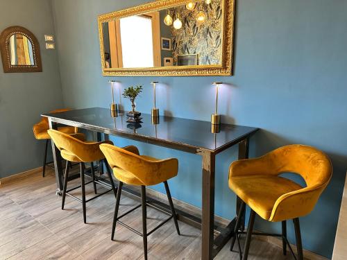 a dining room table with yellow chairs and a mirror at AlCivico3 in Civitanova Marche