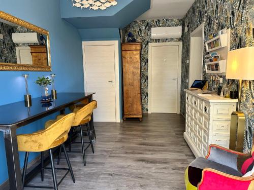 a dining room with blue walls and yellow chairs at AlCivico3 in Civitanova Marche