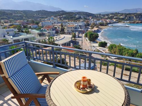 a table and chairs on a balcony with a view of the ocean at Almyrida Beach Bungalow Sea Front in Chania