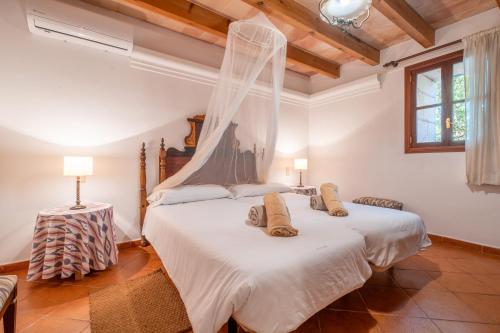 two beds in a room with wooden ceilings at Ses Estaques in Manacor