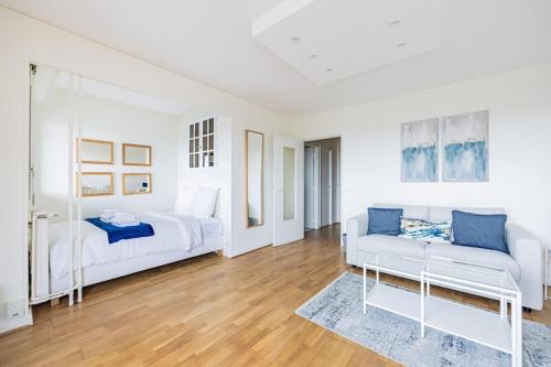 - une chambre blanche avec 2 lits et un canapé dans l'établissement Montparnasse - Vue Tour Eiffel - Balcon, à Paris