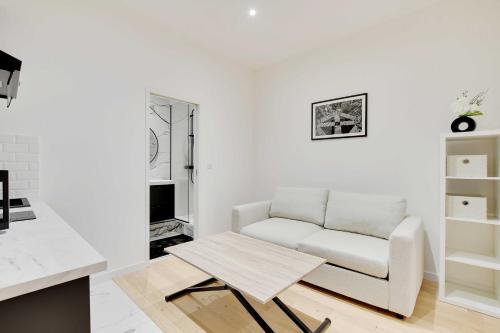 un salon blanc avec un canapé et une table dans l'établissement Cosy modern flat - 1BR- 4P- Oberkampf, à Paris