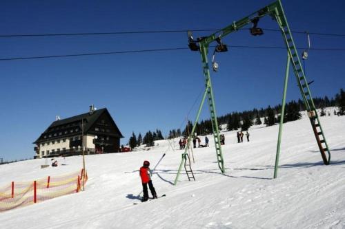 a person on skis in the snow next to a ski lift at Dvorská Bouda in Strážné