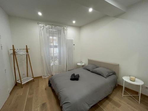 une chambre blanche avec un grand lit et une fenêtre dans l'établissement Le Magnifique, Hyper centre, à Toulouse