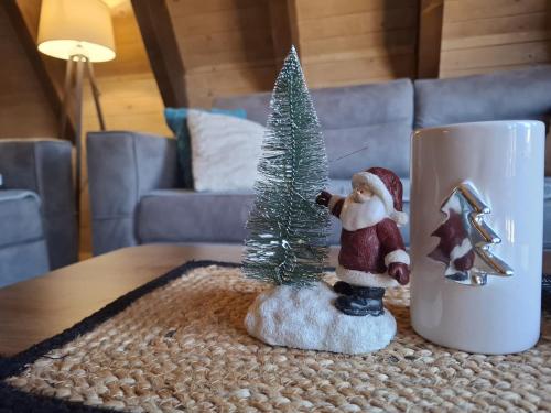 a miniature christmas tree on a table next to a mug at Duly Chalet in Kolašin